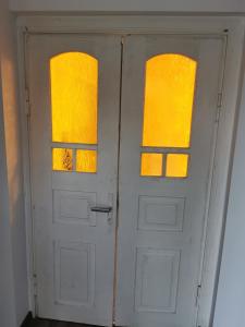 a white door with two windows in a room at Buglandia in Parośla