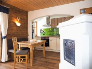 a kitchen and dining room with a table and a fishtank at Haus Alpenflora in Ramsau