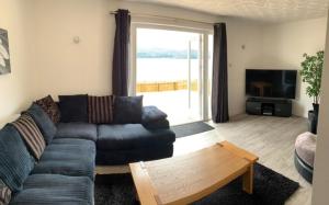 a living room with a couch and a large window at Loch Ness Cottage in Fort Augustus