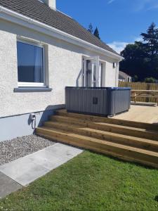 a deck with stairs in front of a house at Loch Ness Cottage in Fort Augustus
