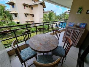 een tafel en stoelen op een balkon met uitzicht bij Apartamento mobiliado Beach Place Porto das Dunas in Prainha