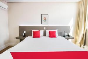 a bedroom with a large white bed with red pillows at Hotel InterAmericana in Americana