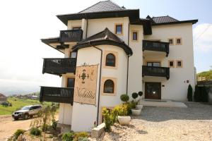 a house with a sign on the side of it at Nobillis - Carpathian Residence in Peştera