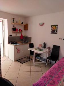 Zimmer mit einer Küche, einem Tisch und einem Schreibtisch in der Unterkunft STUDIO ST GREGOIRE Au Pied des Vosges et Vignoble ! in Munster