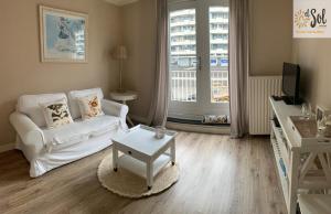 a living room with a white couch and a table at El Sol Zandvoort in Zandvoort