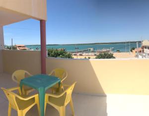 d'une table et de chaises sur un balcon avec vue sur l'océan. dans l'établissement Pousada O Mineiro - frente para o rio, à Galinhos