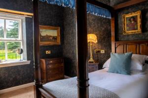 1 dormitorio con cama con dosel y ventana en Melville Castle Hotel, en Edimburgo