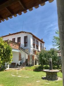 a large white house with a staircase in a yard at Morada Campestre a 45 minutos de Madrid in Chozas de Canales