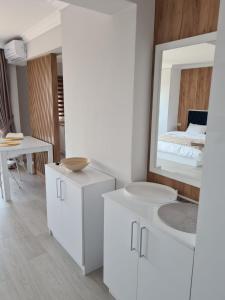 uma casa de banho branca com um lavatório e um espelho em Modern Studio em Oradea