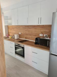 uma cozinha com armários brancos e um forno com placa de fogão em Modern Studio em Oradea