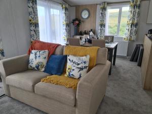 a living room with a couch with pillows on it at Mawgan Pads Mawgan Porth in Mawgan Porth