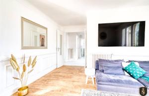 uma sala de estar com um sofá azul e uma televisão em Grande maison 160 m2 6 chambres à Caen em Caen