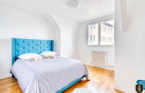 Schlafzimmer mit einem großen Bett mit blauem Kopfteil in der Unterkunft Grande maison 160 m2 6 chambres à Caen in Caen
