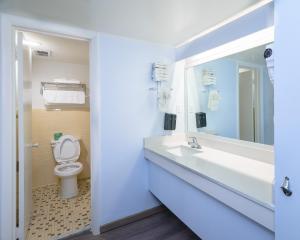 a bathroom with a toilet and a sink and a mirror at Heart of Manteo in Manteo