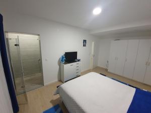 a bedroom with a bed and a walk in shower at Apartman Libertas in Posušje