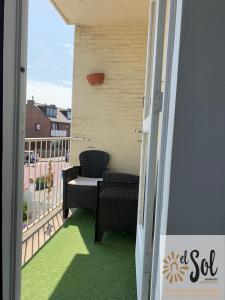 einen Balkon mit einem Sofa und einem Stuhl auf dem Balkon in der Unterkunft El Sol Zandvoort 2 in Zandvoort