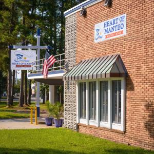 a brick building with an american flag and a cross at Heart of Manteo in Manteo