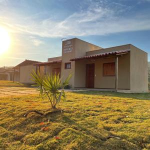 a building with a palm tree in front of it at Pousada Império de Minas in Capitólio