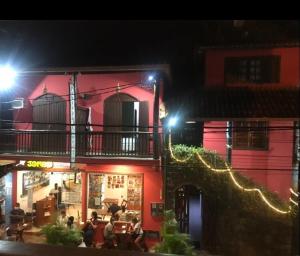 un grupo de personas sentadas fuera de un edificio por la noche en Pousada Estrela, en Itacaré