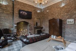 - un salon avec un canapé en cuir et un mur en briques dans l'établissement The Oldgate, à Morpeth