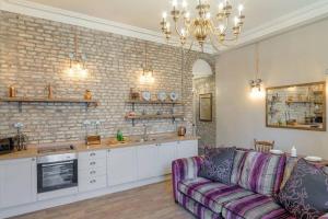 a living room with a couch and a kitchen at The Collingwood in Morpeth