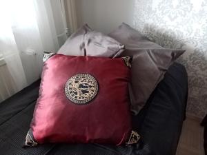 uma almofada vermelha sentada em cima de uma cama em kolmio lähellä keskustaa em Forssa