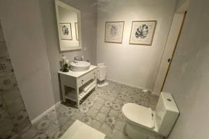 a bathroom with a white toilet and a sink at Craftsman's House in Nordeste