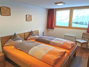 een slaapkamer met 2 bedden met kussens erop bij Chalet Enzian in Riederalp