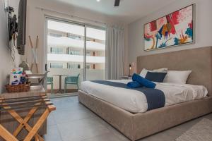 Un dormitorio con una cama grande y un balcón. en The Gallery Condos Playa de Carmen, en Playa del Carmen 207 fotos más