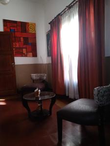ein Wohnzimmer mit einem Tisch und einem Fenster in der Unterkunft Casa del Arte in Salta