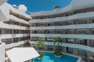 una imagen de un edificio de apartamentos con piscina en The Gallery Condos Playa de Carmen, en Playa del Carmen