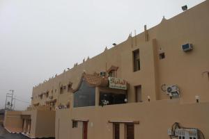 a building with a sign on the side of it at Al Samia apartment in Baljurashi