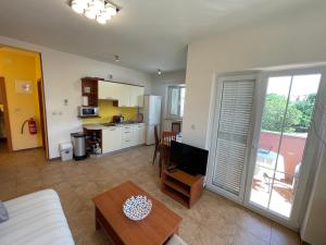 ein Wohnzimmer mit einem Sofa und einem Tisch sowie eine Küche in der Unterkunft Apartman 7- Daniel in Medulin