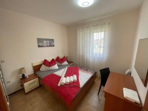 sypialnia z łóżkiem z czerwonymi poduszkami i biurkiem w obiekcie Apartment 7 - Sea View - Daniel w Medulinie
