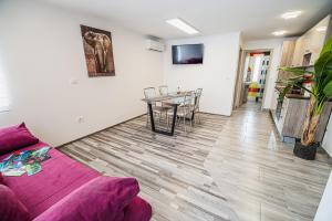 a living room with a purple couch and a table at CUDERLAND - Petra in Kobarid