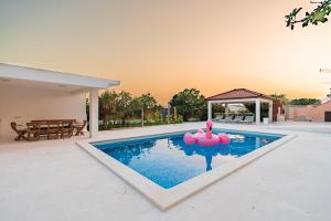 a swimming pool with pink inflatable balls in the water at Villa Summer in Rtina