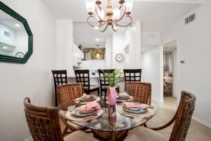 a dining room with a glass table and chairs at Royal Palm 203 in Marco Island