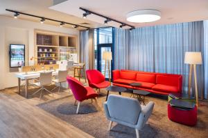 - un salon avec un canapé et des fauteuils rouges dans l'établissement Holiday Inn Prague Airport, an IHG Hotel, à Prague