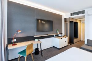 een hotelkamer met een bureau en een tv aan de muur bij Holiday Inn Prague Airport, an IHG Hotel in Praag
