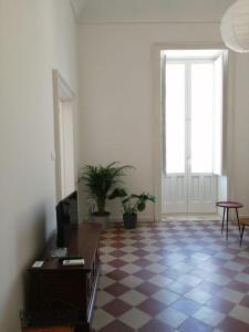 sala de estar con suelo a cuadros y ventana en Antico Mercato Ortigia Apartment en Siracusa
