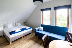 a bedroom with a bed and a blue couch at Czar Mamry Apartamenty in Węgorzewo