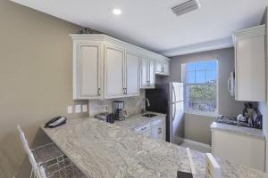 a kitchen with white cabinets and a counter top at Olde Marco Inn #302 in Marco Island