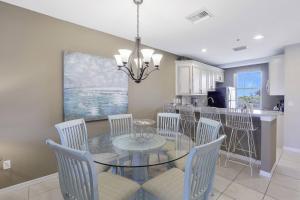 a dining room with a glass table and chairs at Olde Marco Inn #302 in Marco Island