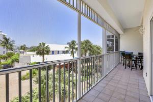 a balcony with a view of the beach and palm trees at Olde Marco Inn #302 in Marco Island +20 photos