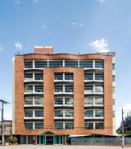 a red brick building with a lot of windows at Hotel Parque 63 in Bogotá