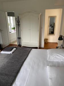 a bedroom with a large bed and a large cabinet at Le Moulin Bleu in Saint Cyr-sous-Dourdan