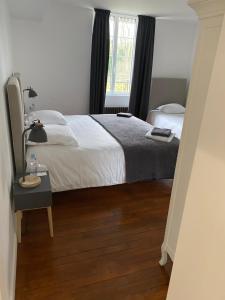 Un dormitorio con una cama grande y una ventana en Le Moulin Bleu, en Saint Cyr-sous-Dourdan