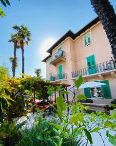 a building with a balcony and a palm tree at Villa Palma in Opatija