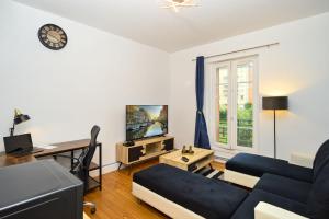 uma sala de estar com um sofá e uma secretária em Le Fil Bleu - CENTRE VILLE - ENTIÈREMENT ÉQUIPÉ em Montluçon