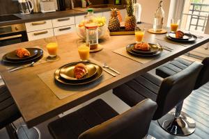 a table with plates of food and glasses of orange juice at Le Fil Bleu - CENTRE VILLE - ENTIÈREMENT ÉQUIPÉ in Montluçon